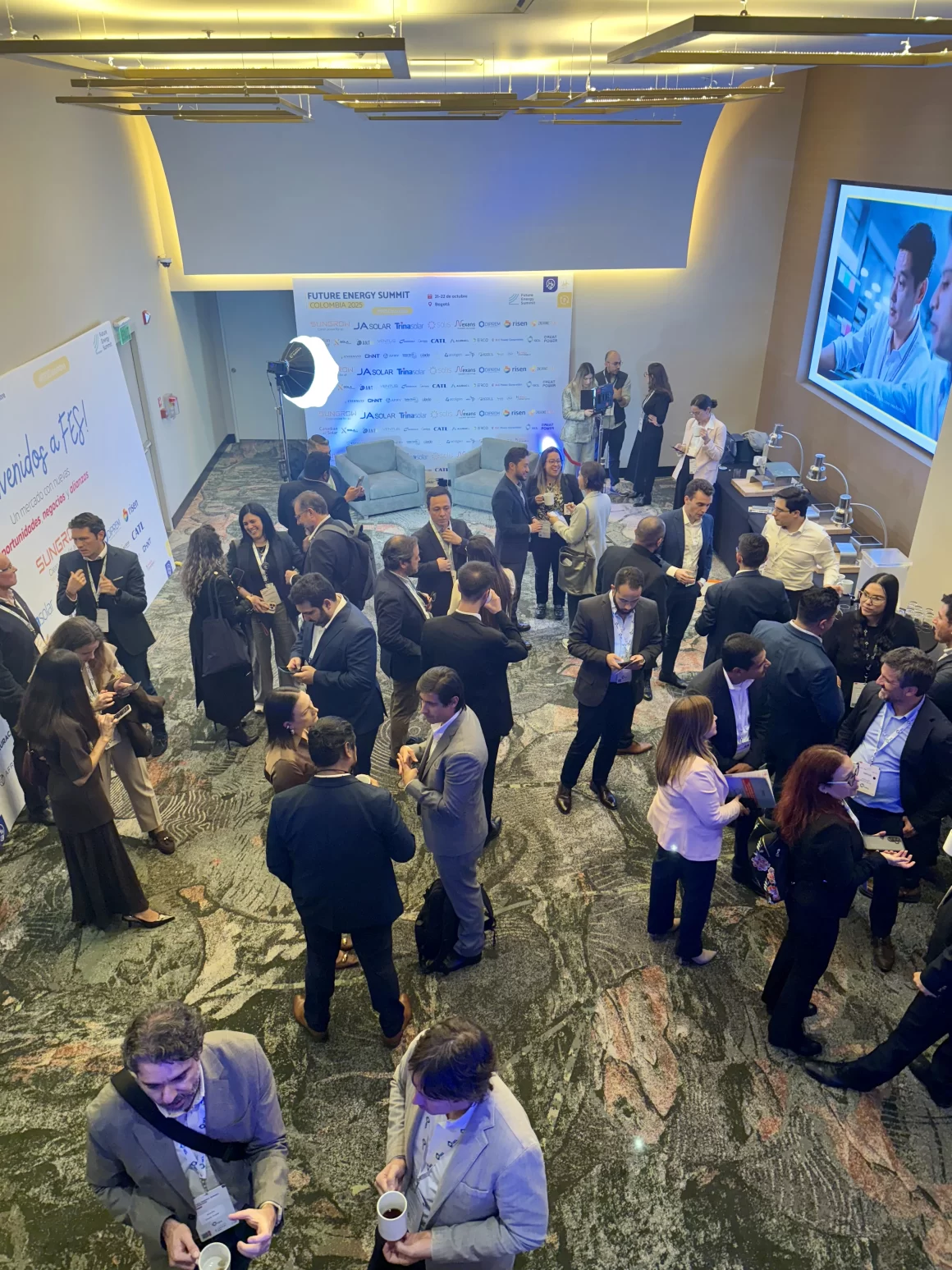 Asistentes del Future Energy Summit en Bogotá conversando y haciendo networking durante una pausa de café.