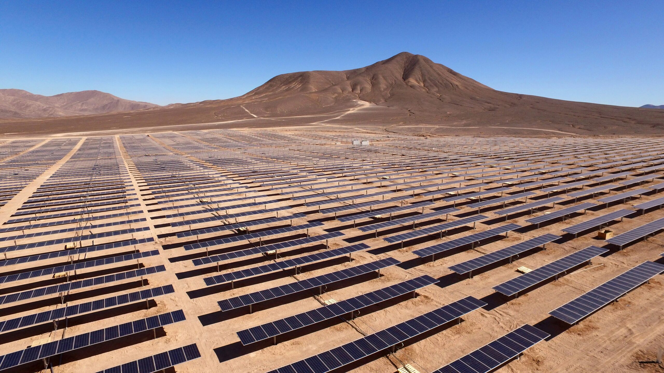 Planta solar en el desierto de Atacama, Chile, con paneles fotovoltaicos a gran escala bajo cielo despejado.
