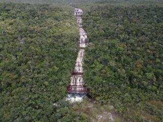 Waterfall cascading through dense rainforest in Araracuara, Caquetá, Colombia, surrounded by lush tropical forest, symbolizing water, biodiversity, and life in the Amazon region.