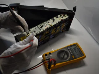 Technician repairing a lithium-ion battery pack for electric mobility using diagnostic testing equipment.
