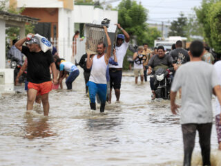 Flooded streets in Montería, Córdoba, Colombia, after heavy rains, with homes and vehicles partially submerged.