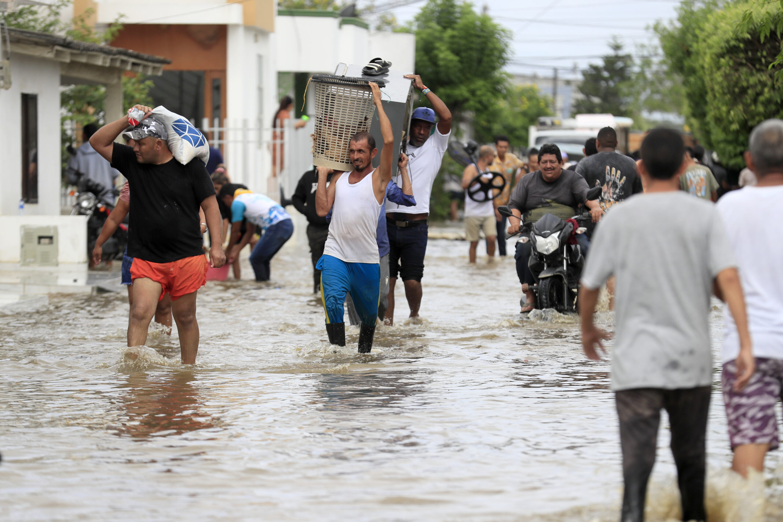 Flooded streets in Montería, Córdoba, Colombia, after heavy rains, with homes and vehicles partially submerged.