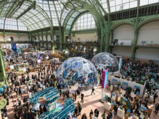 Interior view of the Grand Palais in Paris during ChangeNOW 2026, with sustainable innovation stands and attendees exploring the exhibition.