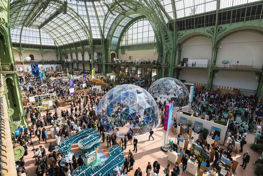 Interior view of the Grand Palais in Paris during ChangeNOW 2026, with sustainable innovation stands and attendees exploring the exhibition.