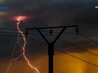 Lightning striking near power transmission infrastructure during a storm, symbolizing the tension between energy reliability, climate risk and the future of Colombia’s energy transition.