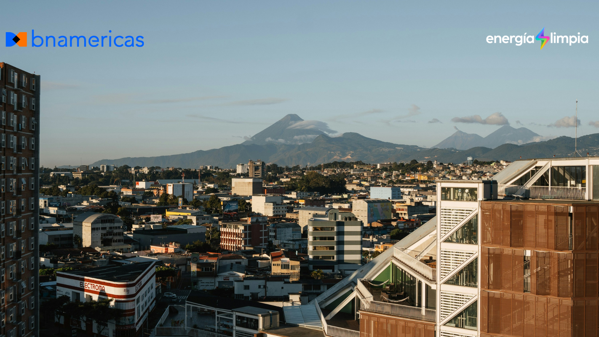 Vista urbana de Ciudad de Guatemala con edificios modernos y volcanes al fondo, en el contexto de la expansión renovable, transmisión eléctrica e integración energética regional en Centroamérica.