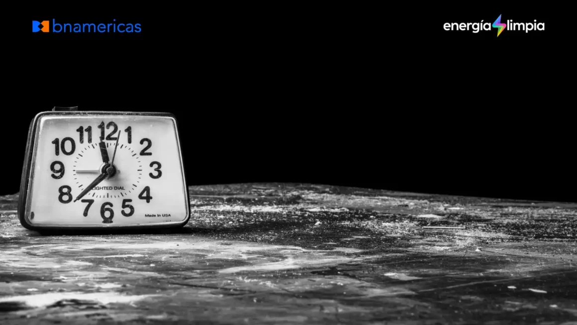 Reloj despertador antiguo en blanco y negro, rodeado de oscuridad, con los logos de BNamericas y Energía Limpia.