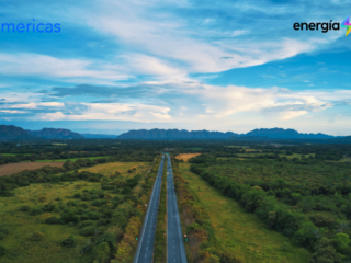 Vista aérea de una carretera que atraviesa el paisaje verde de Ibagué, Tolima, con los logos de BNamericas y Energía Limpia.